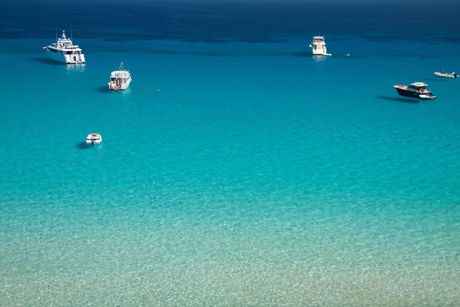 Mare turchese visto dall'alto con barche e yacht all'ancora